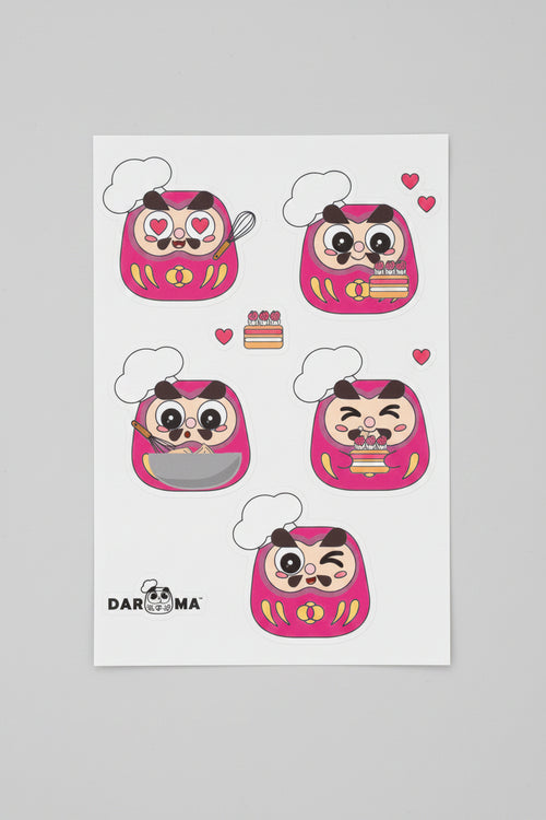 A sheet of five pink Daruma stickers .Our Pastry Chef Andy! The brand logo on the bottom-left corner with white background.